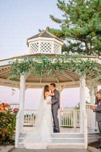 Bride and groom beneath the waterfront gazebo at Amarante's Sea Cliff in historic Morris Cove