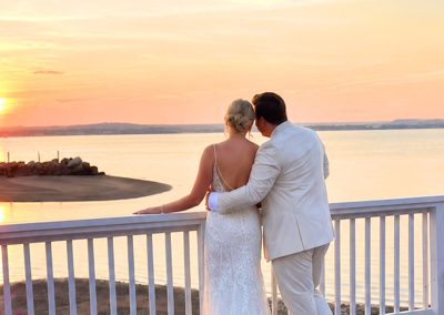 Bride and groom embracing at sunset overlooking Long Island Sound at Amarante's Sea Cliff